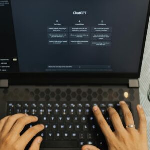 Hands typing on a laptop with ChatGPT open, wireless technology theme.